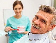 Patient in Newark smiling with dentist as they show good hygiene 