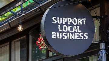 Sign on building that says, “Support Local Business”