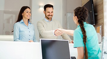 Patient shaking hands with dental team member