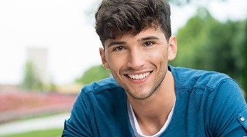 A young adult smiling outside.