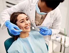 Dentist examining smiling patient's teeth