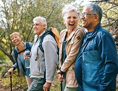 Group of four older adults hiking and laughing 