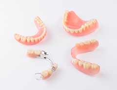 Full and partial dentures arranged in a circle on a white surface