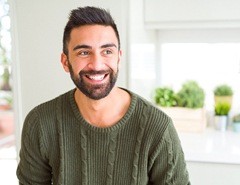 person smiling and sitting in a kitchen