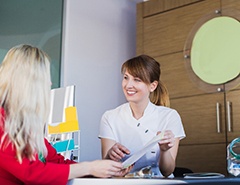 dental team member showing a pamphlet to a patient 