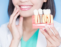 dentist holding a model of dental implants in Newark 