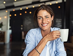 woman holding a white coffee mug 