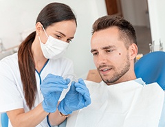 Dental assistant showing patient clear aligner