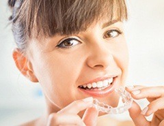 Woman placing Invisalign tray