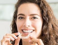 Woman holding Invisalign tray