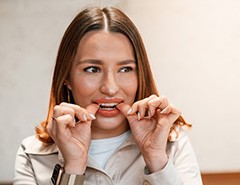 Patient putting on clear aligner in treatment room