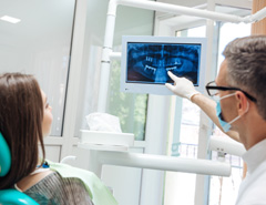 Dentist looking at X-ray with patient 