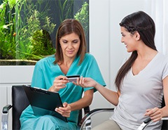 A woman using a credit card to pay for dental care