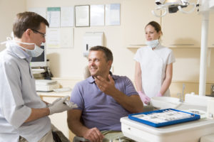 Man in dentla chair talking to dentist