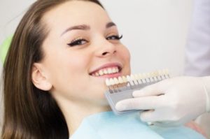 Female patient having her tooth color matched 