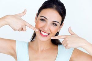 woman pointing to her white smile