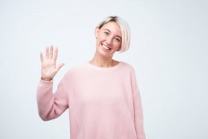 Smiling woman waves at her Newark dentist during COVID-19 pandemic