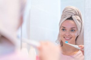 woman using electric toothbrush 