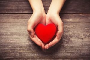 a red plush heart in someone’s hands 