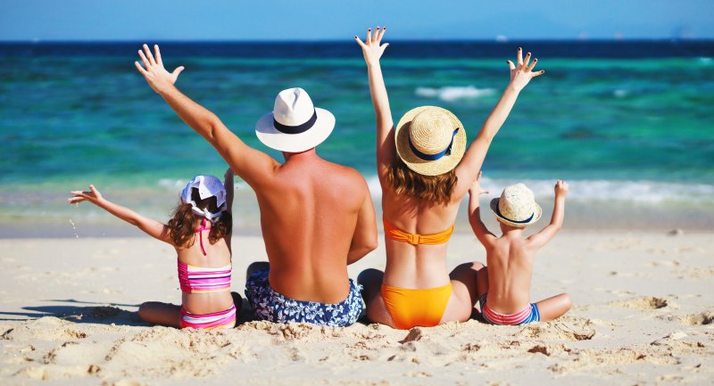 family playing on the beach in the summer