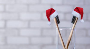 Toothbrushes wearing small Santa hats
